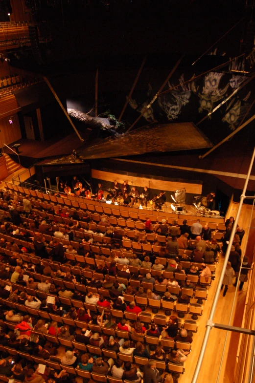 an auditorium or theater with people on the stage watching soing