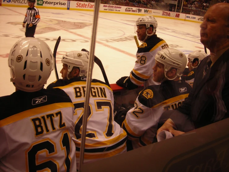 some hockey players standing around talking on the ice