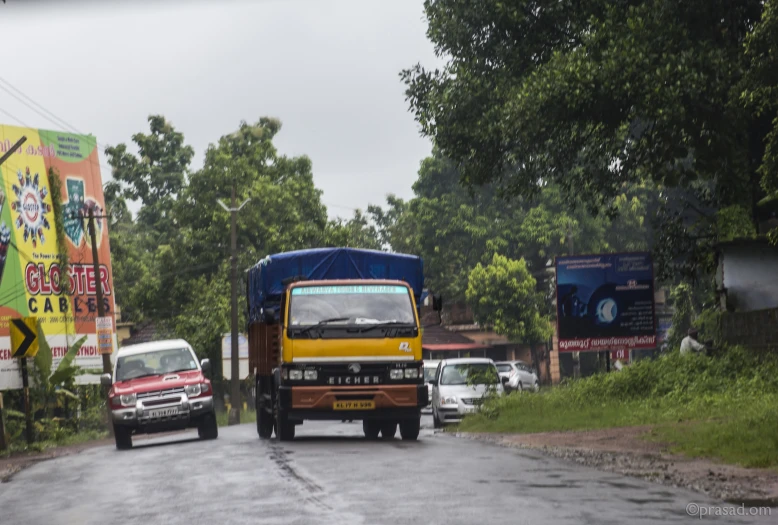 a yellow truck and other vehicles traveling down the road