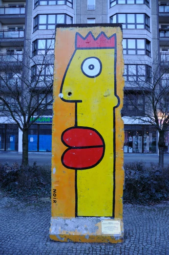 a large yellow painting with red lips and a face with a crown on top