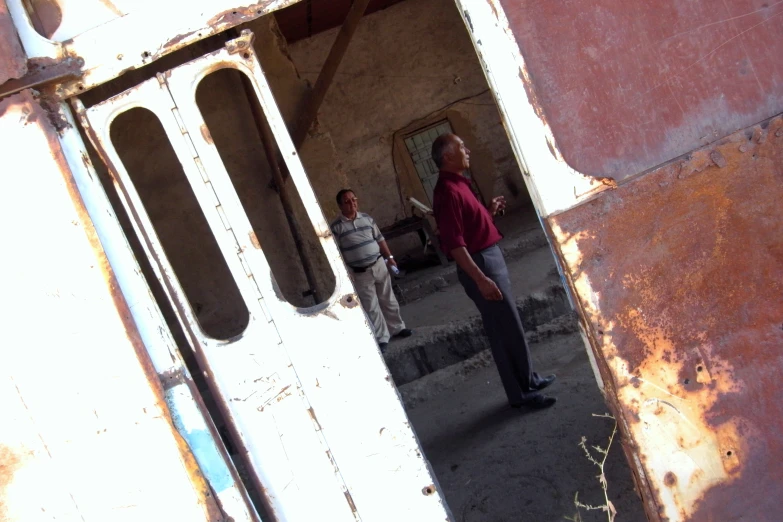 two men standing outside an old building on the street