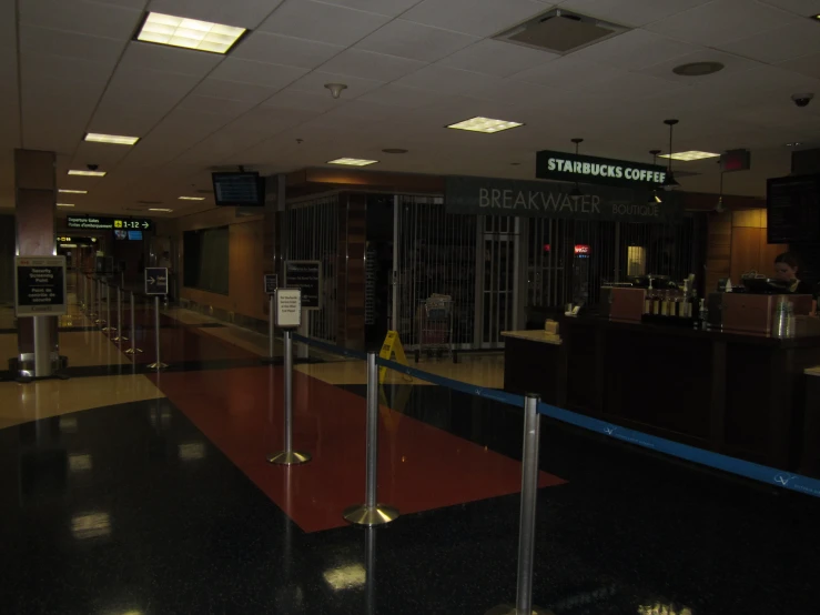 an empty terminal area with luggage carts at its gates