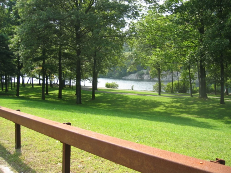 a scenic view of a park with trees, grass and water