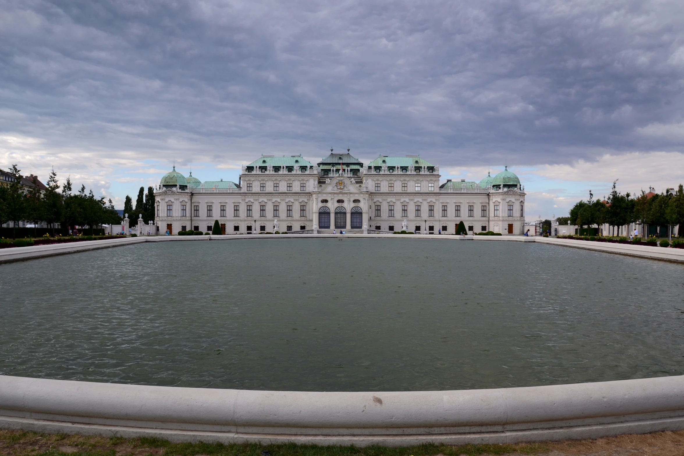 an ornate building with a massive fountain in the middle of a large courtyard