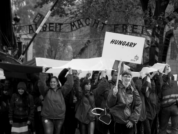 a group of people are walking in the street carrying signs