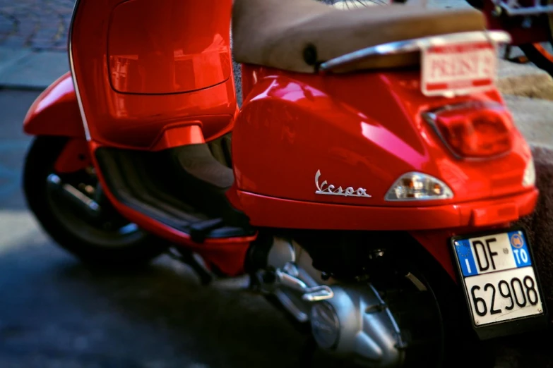 a red motorbike parked on the side of a road