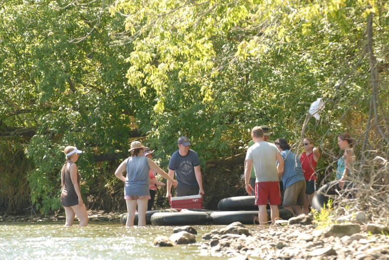 a group of people stand near a river