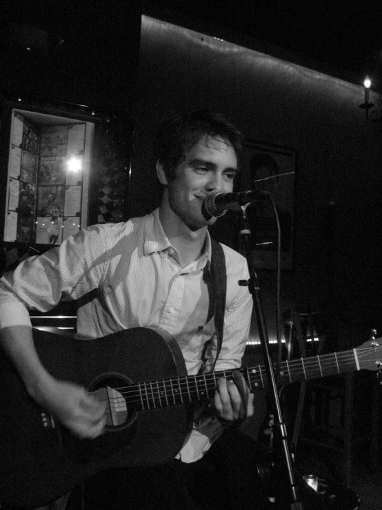 a man that is sitting down with a guitar