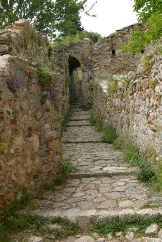 an old stone path leading to a small building