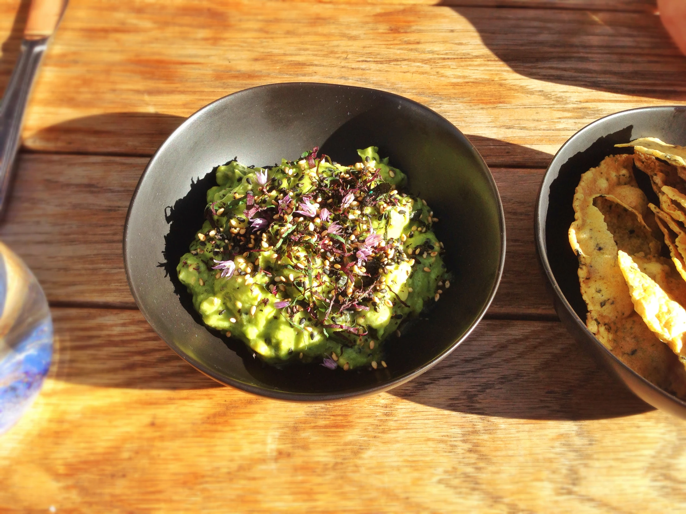 a couple of bowls of guacamole and tortilla chips