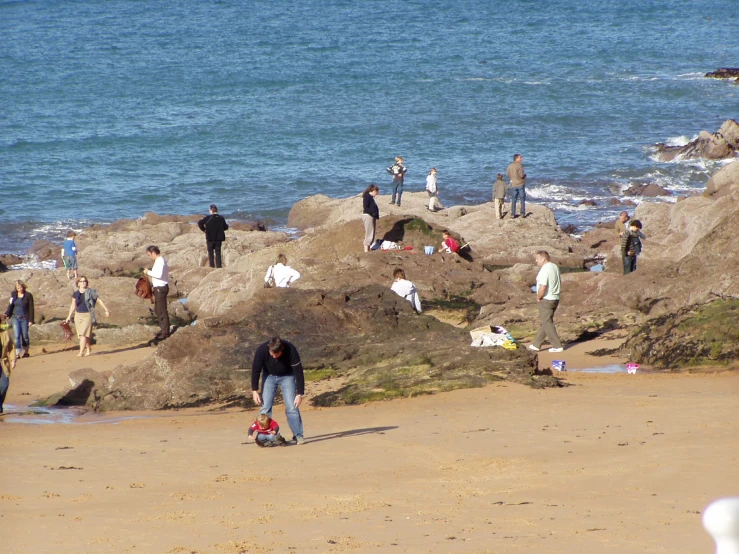 there are many people that are on the rocks by the ocean