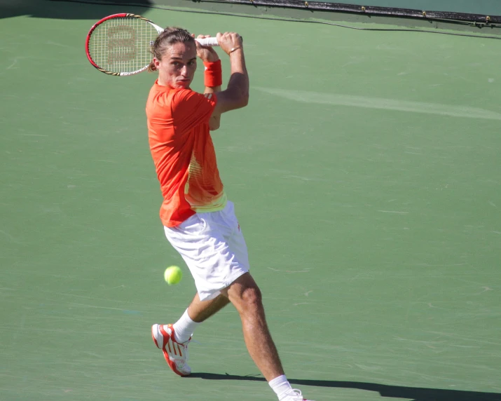 a man taking a swing at a tennis ball