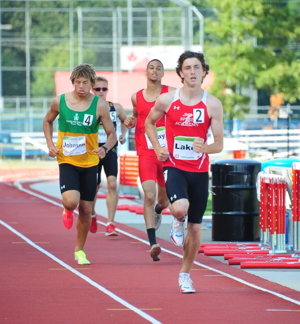 a group of men running down a track in a race