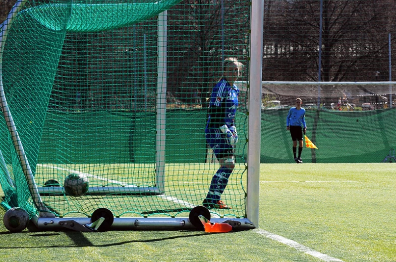 a soccer goalie standing behind an inflatable ball