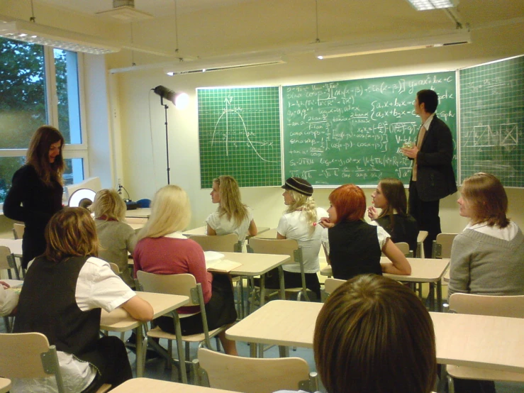 some students in a classroom, one with a teacher teaching
