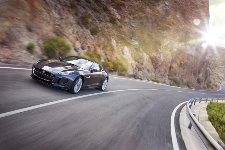 a black sports car driving down a curved road