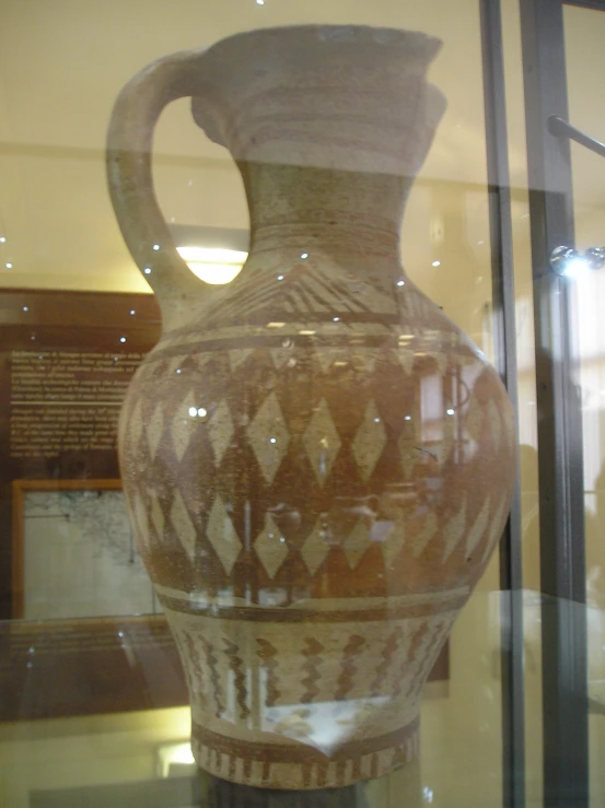 a glass display case with a vase on it