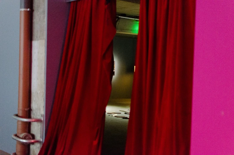 a pink wall with red curtains inside a room