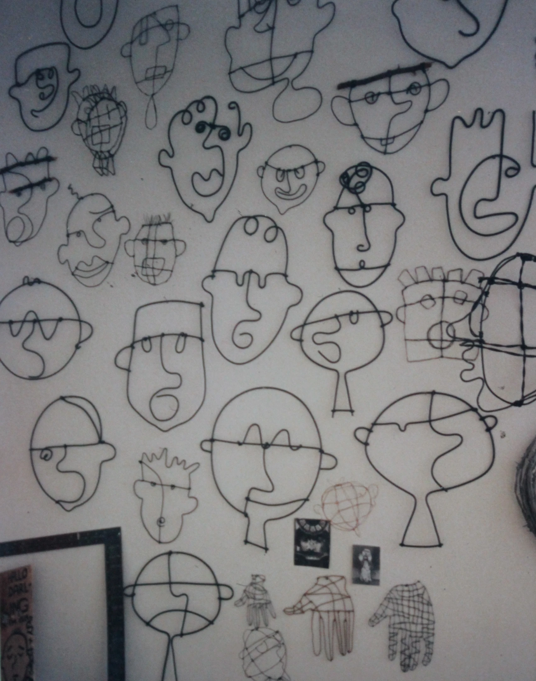 there are many drawing faces hanging on the wall