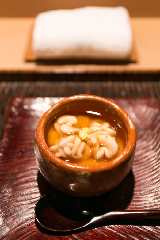 a bowl of soup with beans is on a glass plate