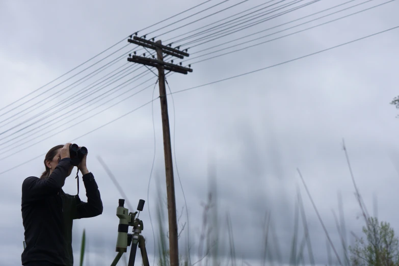 a man wearing a camera is looking through a binoculars