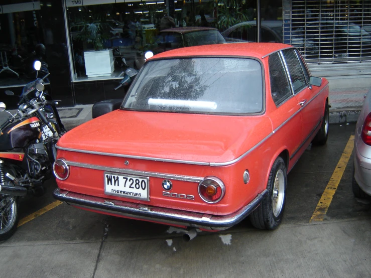 an orange car parked next to another red car