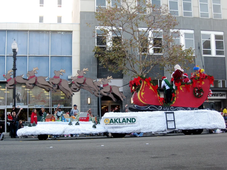 a float is traveling down the street with people around it