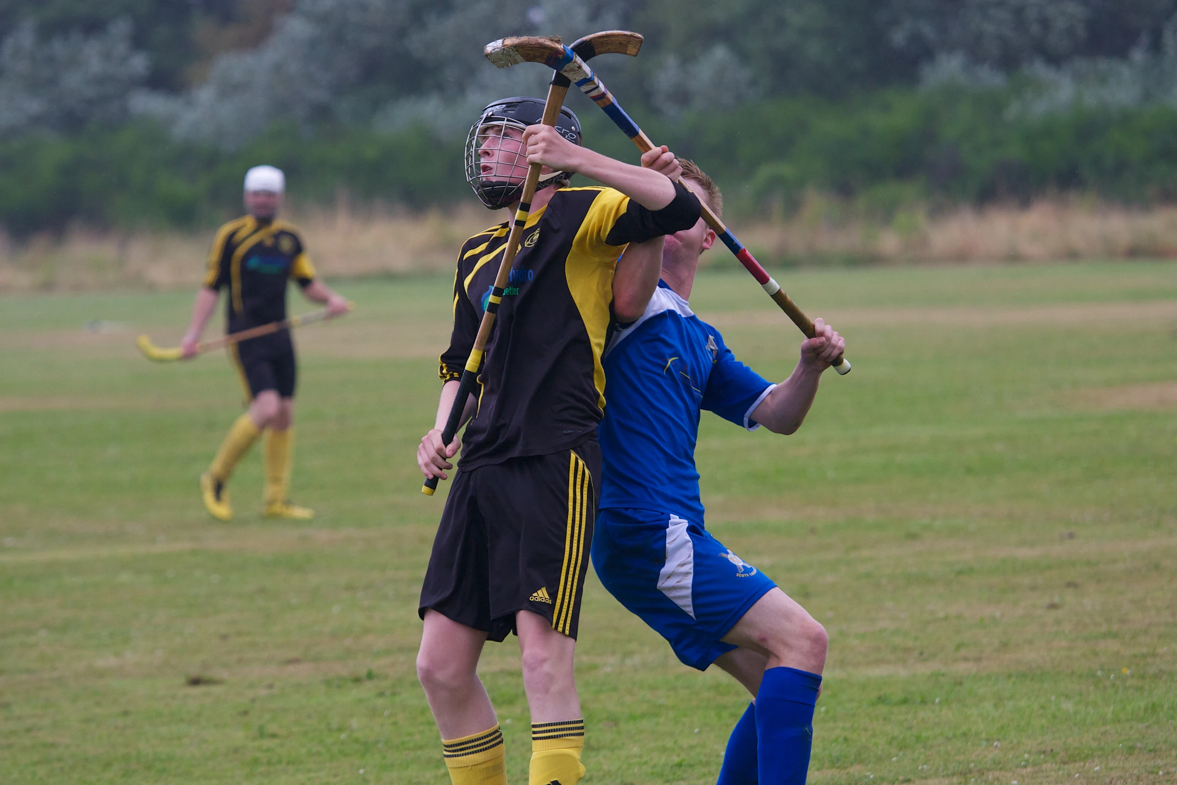 two men fighting over a soccer ball in a field