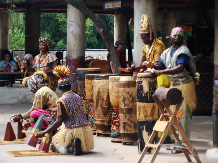 a group of people sitting around in front of drums