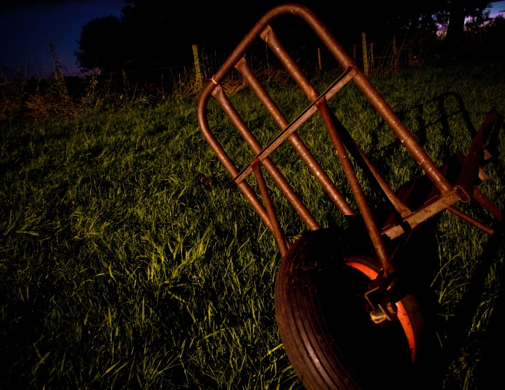 a metal cart in the middle of some green grass