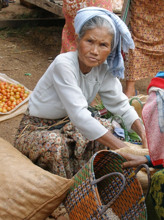 a woman is posing with a large bag full of fruits