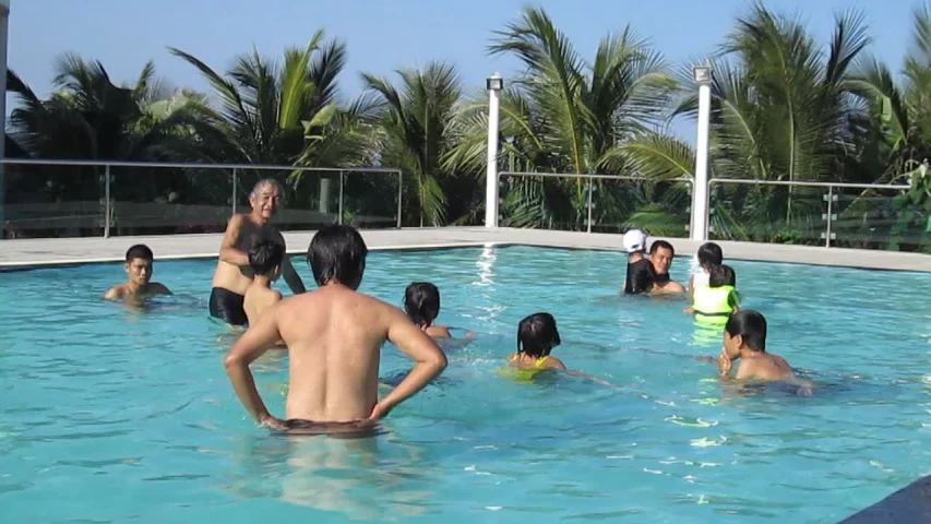 a group of people are sitting around in a pool