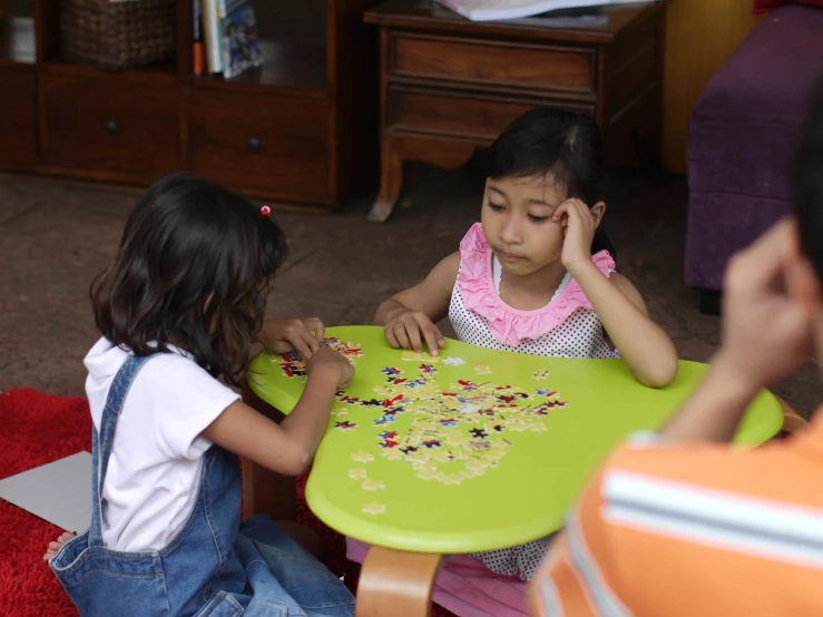 two children playing with the small toys on the table