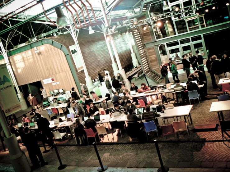 several tables and chairs with people eating and reading