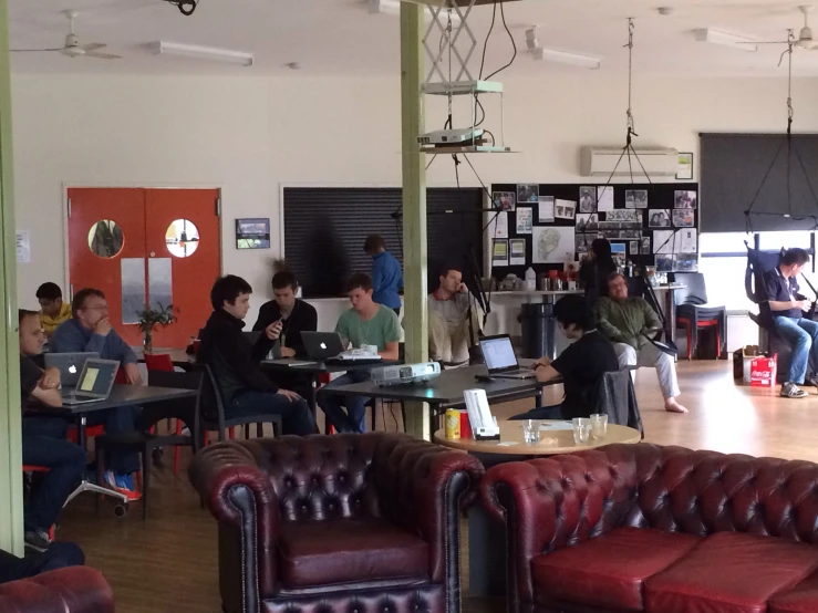 a group of men sitting in chairs inside a building