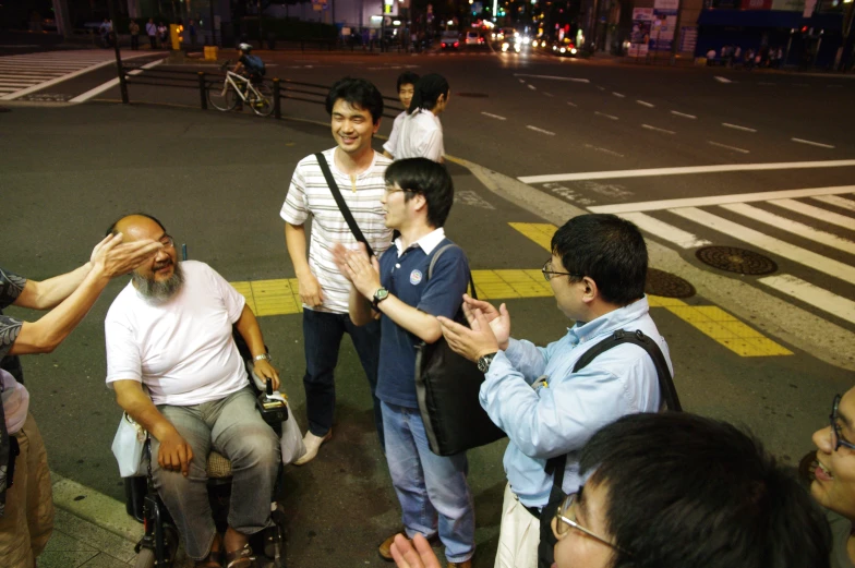 several people on the side walk are talking and exchanging with one another