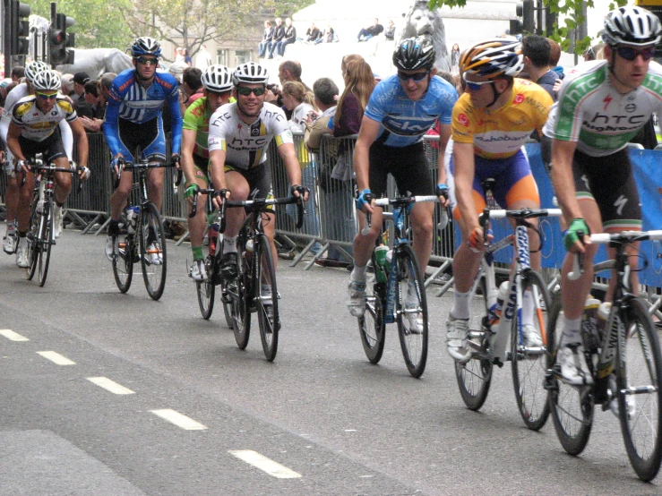 several men riding their bikes through a street