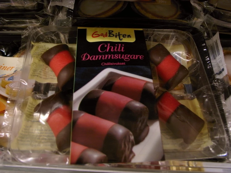 several candies with pink and chocolate are displayed on the shelf