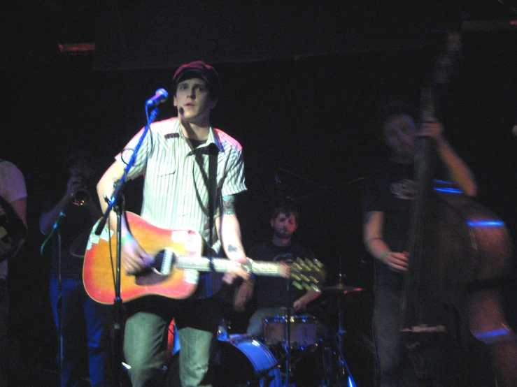 man standing on stage and holding a guitar