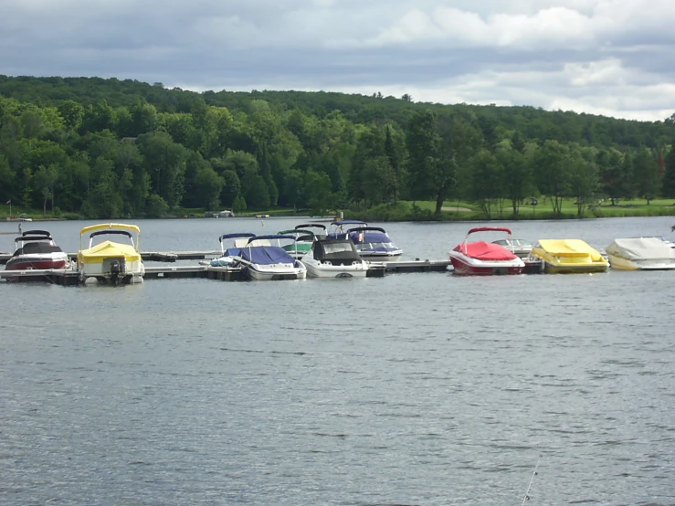 five colored boats are docked next to one another