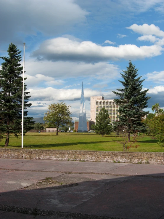 a very tall building sitting behind a green field