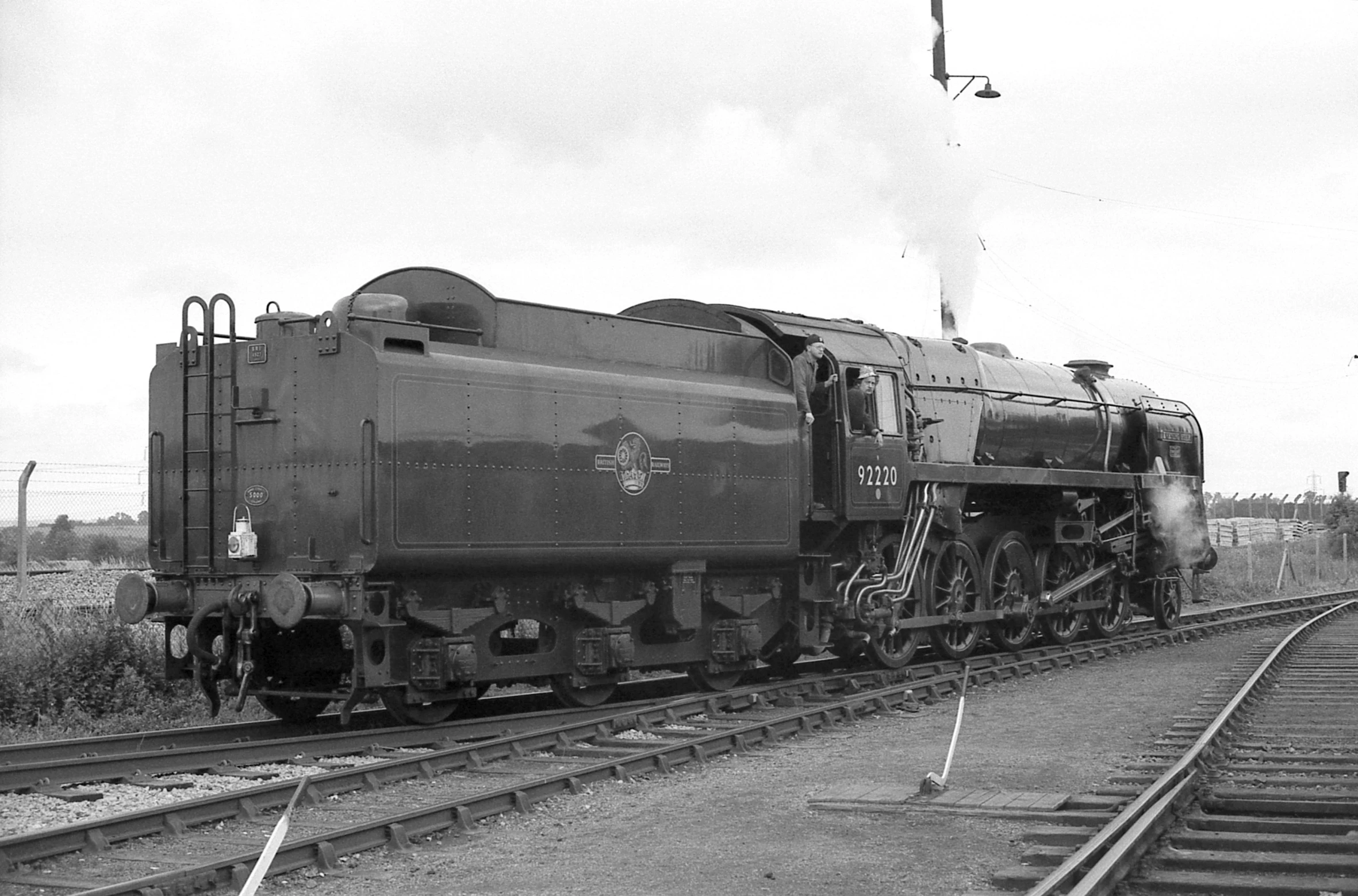 an old black and white po of a train going down the tracks