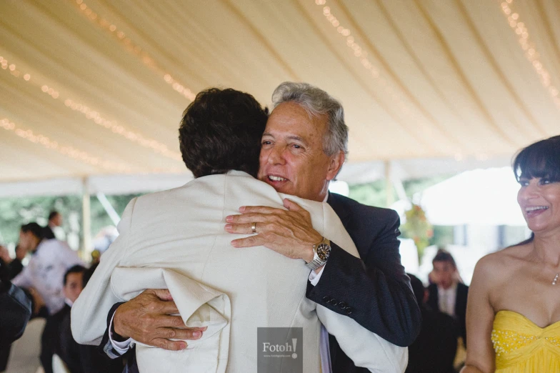 a woman hugging an old man at a formal function