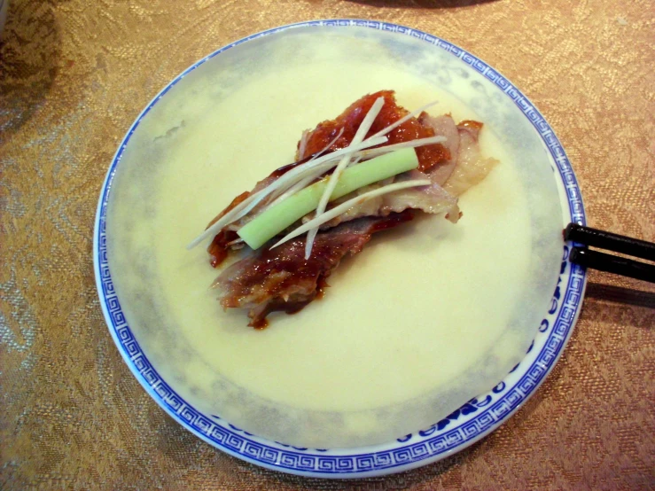 plate with food and chop sticks on wooden table