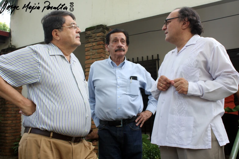 three men standing near each other on a sunny day