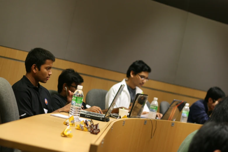 students working on laptops in a large lecture hall
