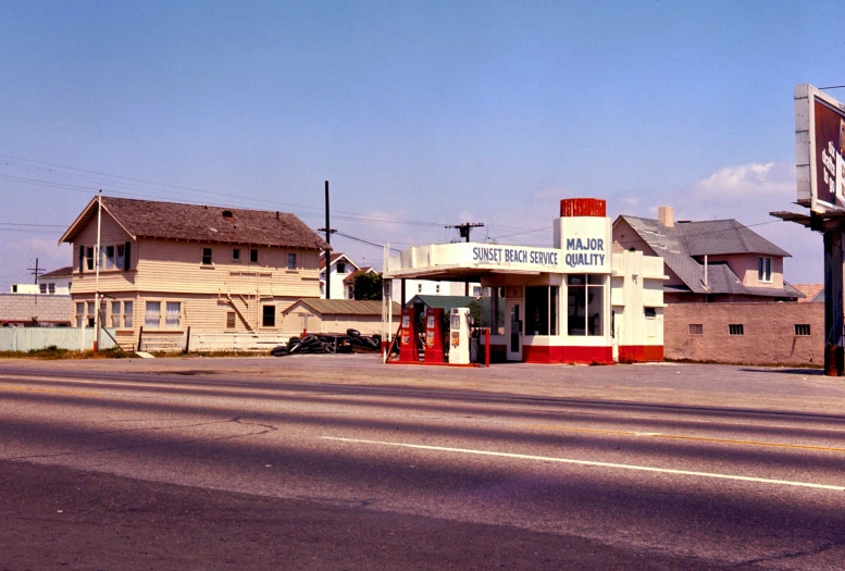 an old gas station in a town square with a building