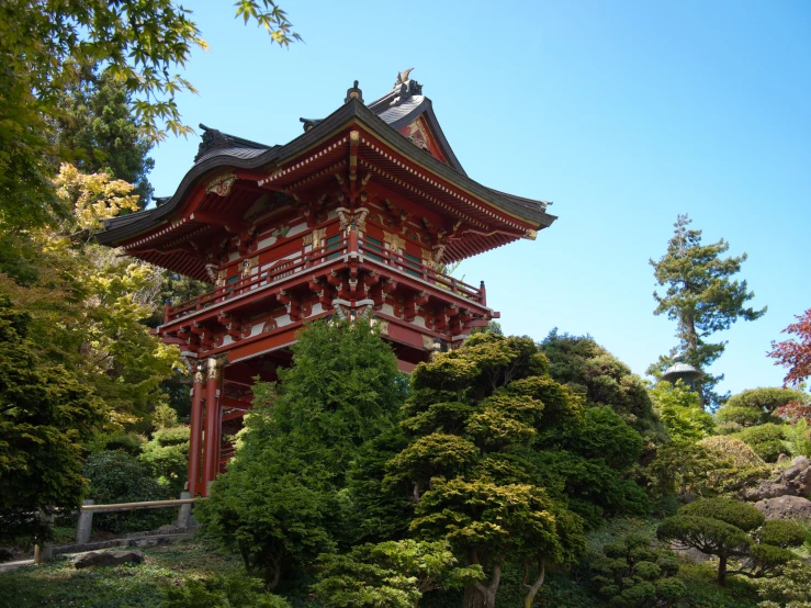 an ornate red building with trees surrounding it