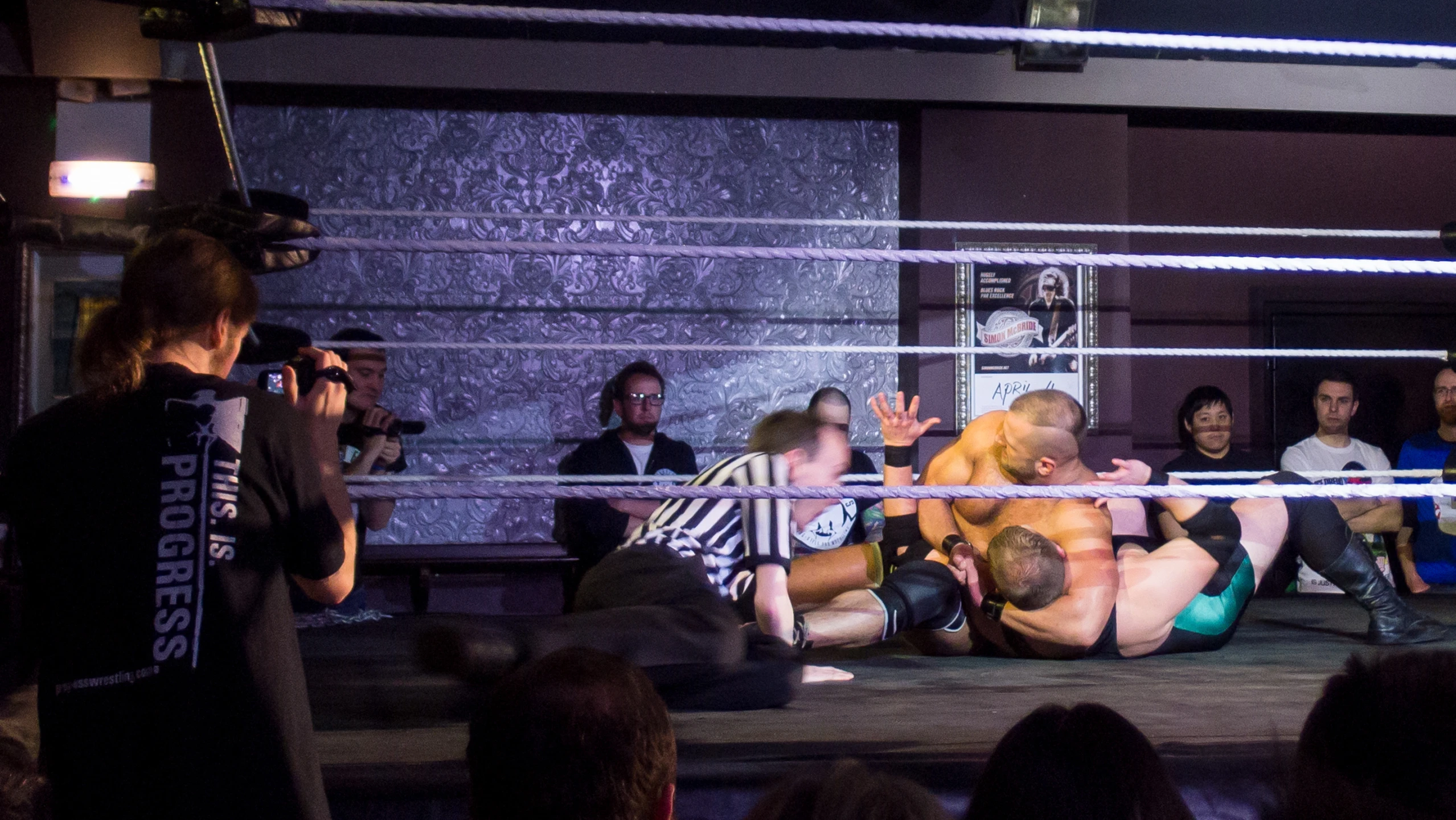 two people wrestling while an audience looks on