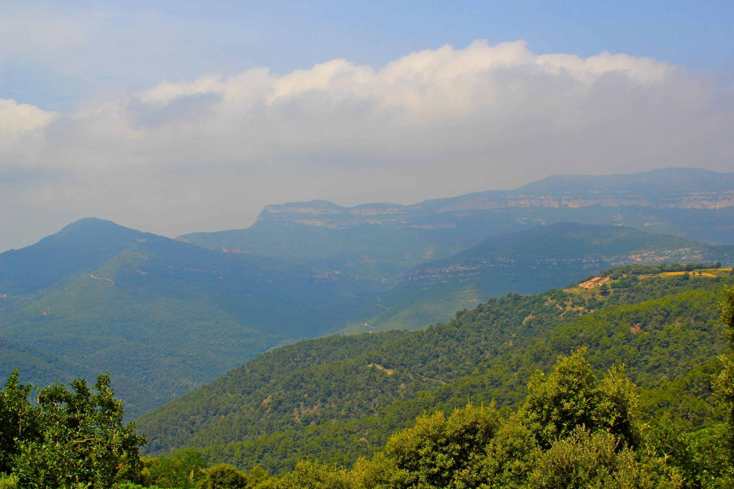 a mountain with lush green trees, and a city in the background